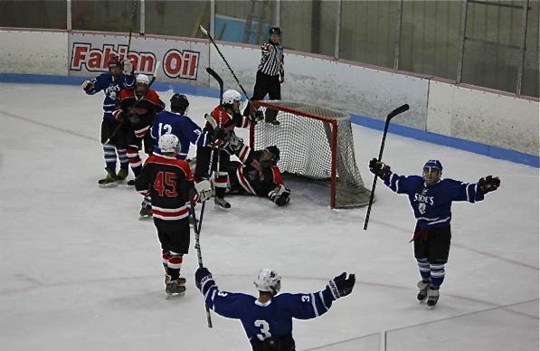 On the right, sophomore Ryan Berard (Millville, Mass.) throws his arms up in celebration after scoring his fourth goal of the night. He is greeted by his teammate, sophomore Mario Lemieux (Biddeford, Maine).